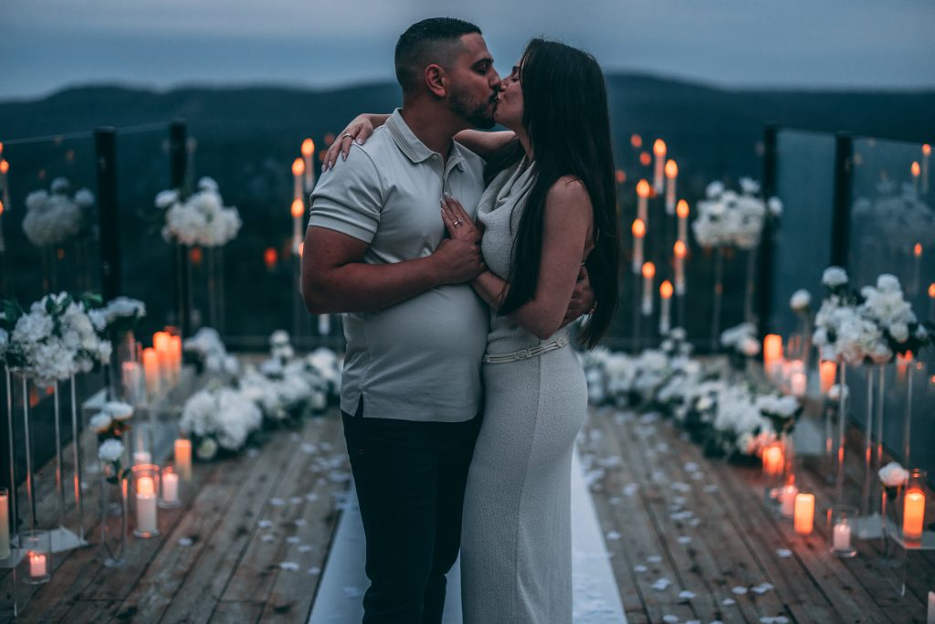 The newly engaged couple kissing among the candles
